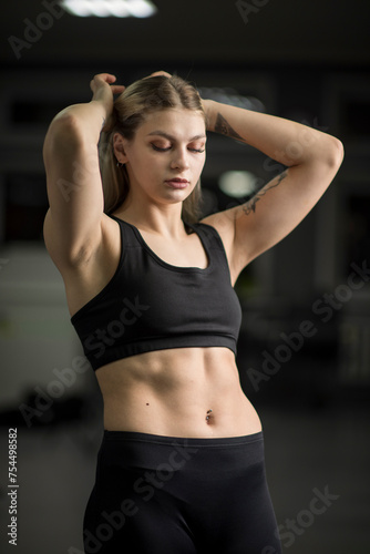 Portrait of a young beautiful blonde sportswoman in the gym.