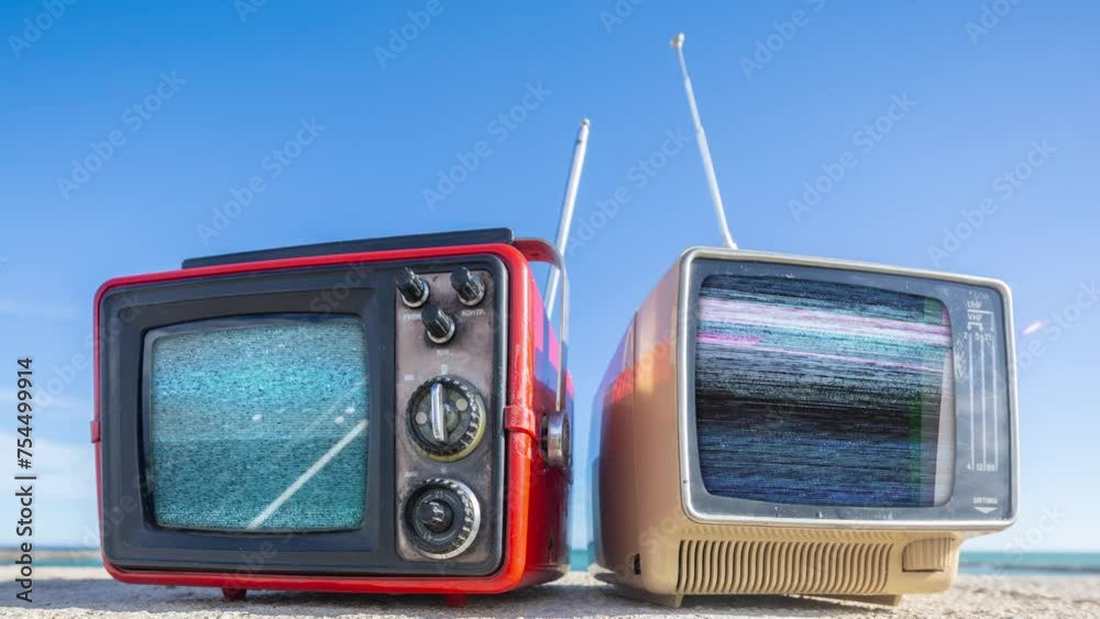 retro televisions with glitch on the screen on a beach