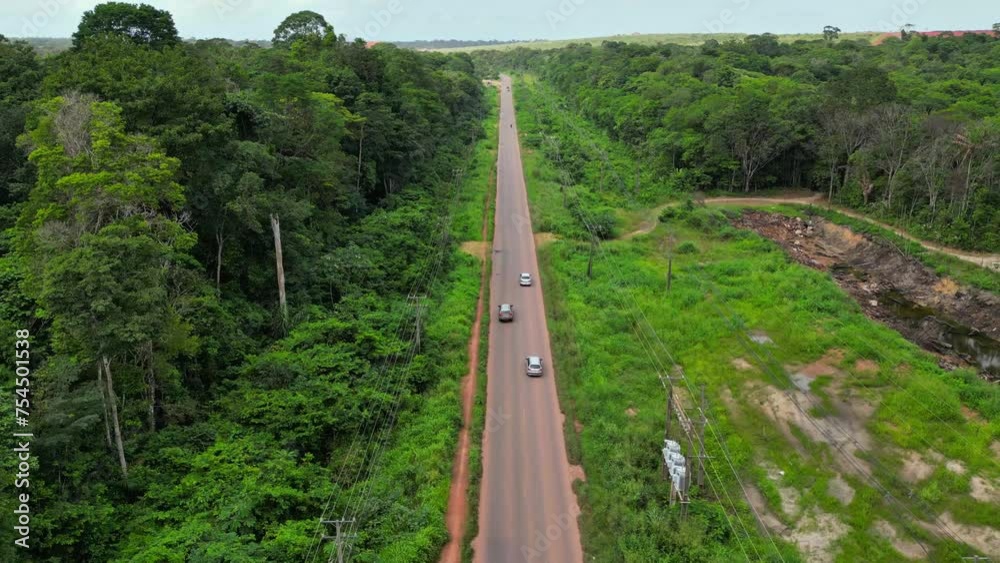 Aerial drone view of the vehicles on a paved highway cutting through the Amazon rainforest Aerial drone view of the vehicles on a paved highway cutting through the Amazon rainforest