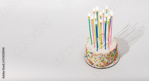 Birthday bento cake with high tall candles, fire light. Banner background, copy space for text
