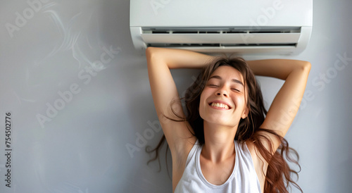 A woman enjoying the cool comfort under the air conditioner, enjoying a home vacation. photo