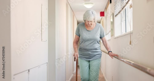 Stick, walking and old woman with a disability in recover or rehabilitation in a clinic for mobility. Healthcare, medical and physiotherapy with a rail elderly female patient alone in a nursing home photo