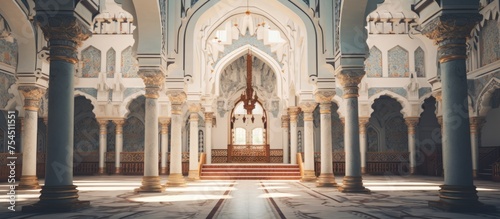 A large mosque with impressive white columns and intricate arches stands tall, showcasing beautiful Islamic architecture. The building exudes grandeur and historical significance.