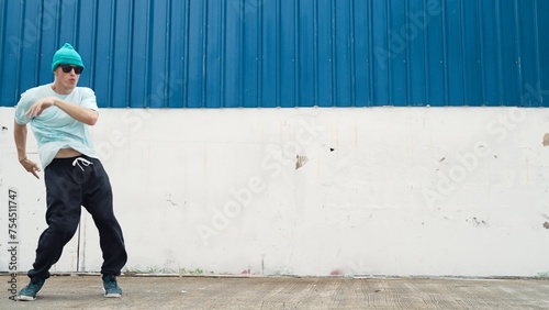 Motion shots of youthful hipster moving in lively groove at street. Caucasian break dance choreographer dancing in hip hop style. Energetic dancer perform b-boy dance. Outdoor sport 2024. Endeavor.