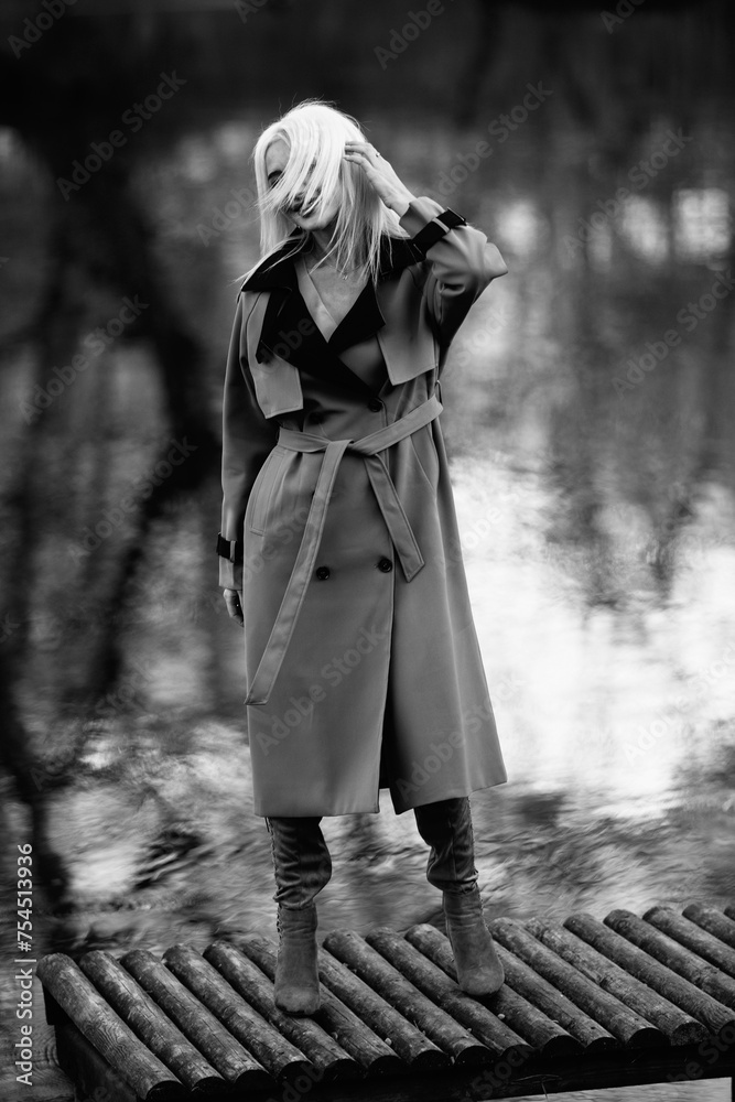 Naklejka premium Portrait of a young beautiful blonde woman outdoors. Black and white photo.