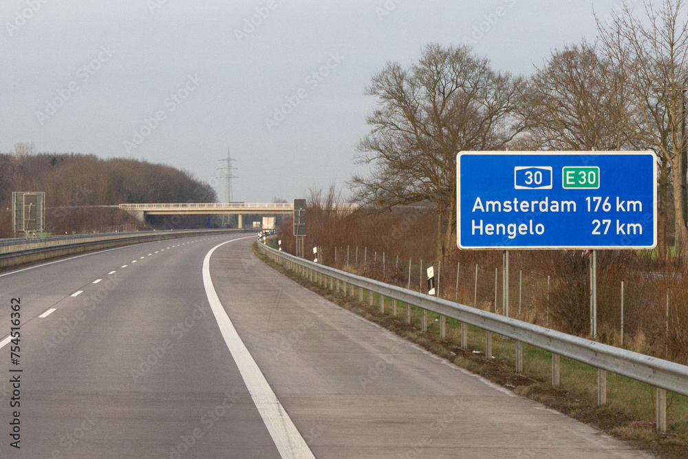 Autobahn A30, E30, Entfernungstafel; Amsterdam 176 km, Hengelo 27 km - obrazy, fototapety, plakaty 