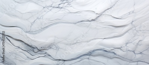 Detailed view of a white marble texture, showcasing intricate patterns and veining characteristic of this luxurious material. The surface reflects light, creating a smooth and elegant appearance.