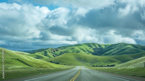 green grass on each side of highway, rolling hills in front with clouds, towards paso robles photo