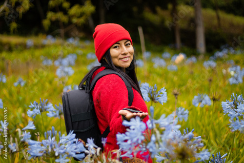 Explorando la belleza invernal,Una joven aventurera admira las flores en el campo bajo la lluvia de invierno,estilo de vida photo