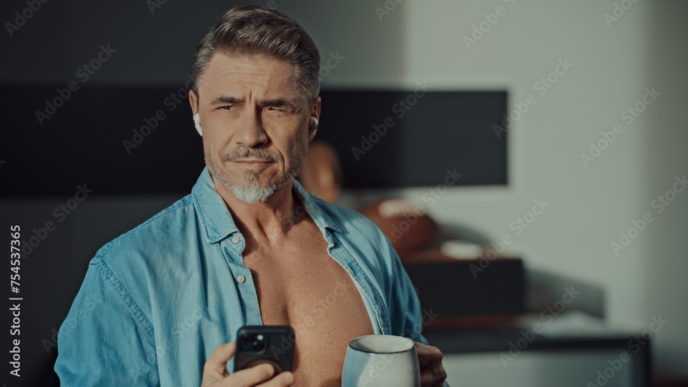 Confident mature man enjoying coffee at home in morning Confident mature man enjoying coffee at home in morning