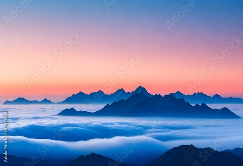 Mountain range with peaks above clouds during sunrise or sunset with a gradient sky from blue to orange