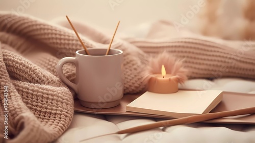 A cup of coffee is on a bed next to a book