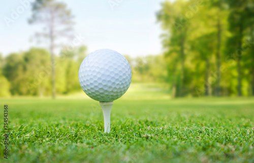 Low angle view of a golf ball on a tee in front of defocused fairway