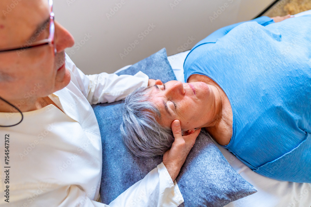 Obraz premium Masseur doing massage to the head of a mature woman