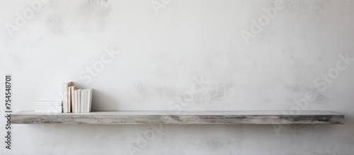 A single book is placed neatly on a cement shelf against a plain white background. The book is upright and appears to be the main focus of the simple composition.