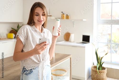 Young woman with bottle of ...