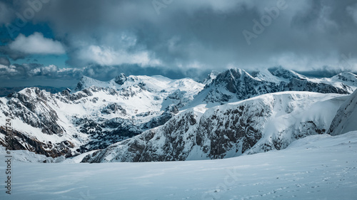 snow covered mountains in winter with heavy clouds in the sky