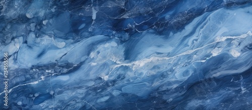 A close-up view of a blue marble texture with prominent white streaks running through it, creating a striking and unique pattern.