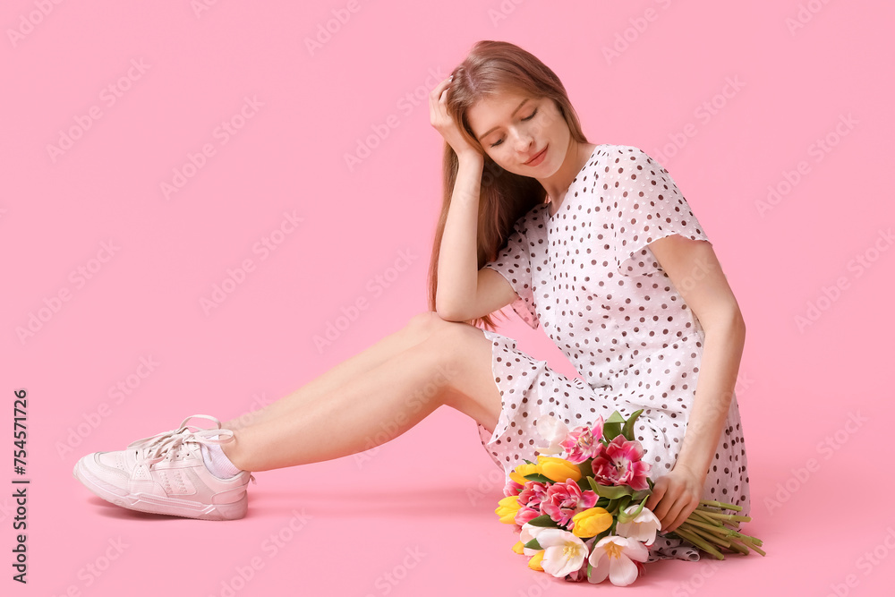 Pretty young woman with bouquet of beautiful tulips sitting against pink background Pretty young woman with bouquet of beautiful tulips sitting against pink background