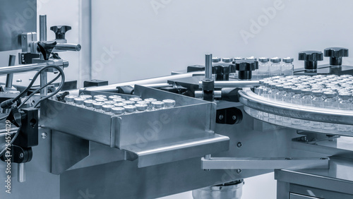 Pharmaceutical industry. Production line machine conveyor with glass bottles ampoules at factory. Pharmaceutical industry concept background.