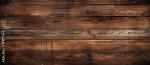 A close-up view of a wooden wall made of brown planks. The texture of the wood is visible  with knots and grain patterns enhancing its rustic appearance.
