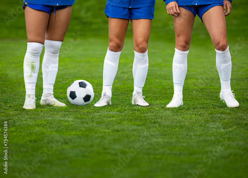 A row of soccer players standing together before a game. Showing feet and legs only. Athletic and fit Female soccer players ready to play and take on any challenge