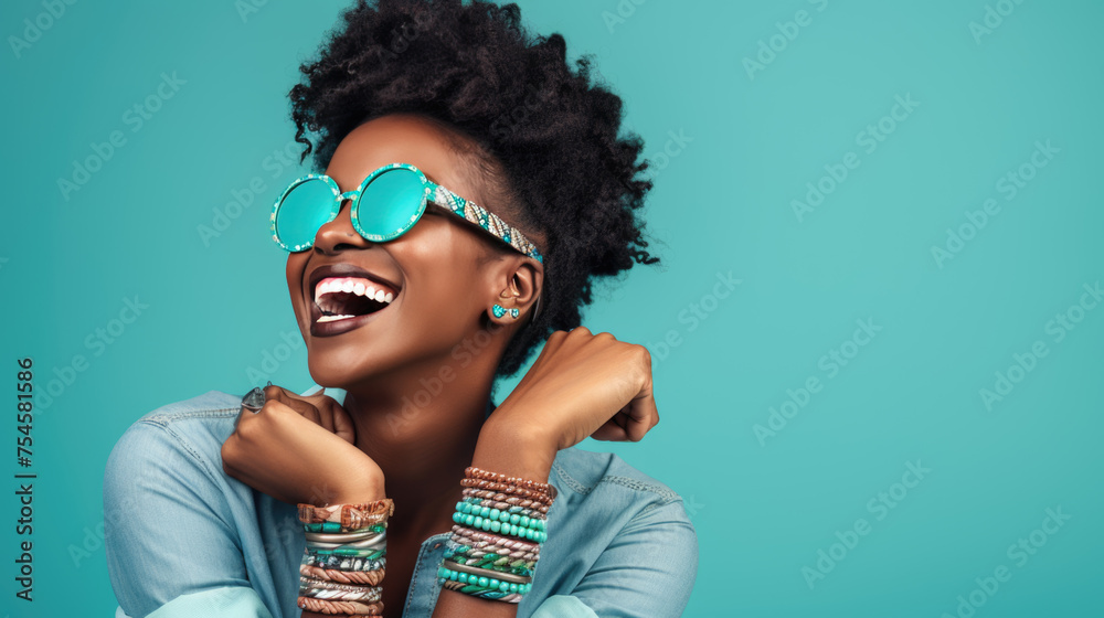 Joyful woman with an afro hairstyle, laughing and wearing turquoise sunglasses against a vibrant turquoise background. Joyful woman with an afro hairstyle, laughing and wearing turquoise sunglasses against a vibrant turquoise background.