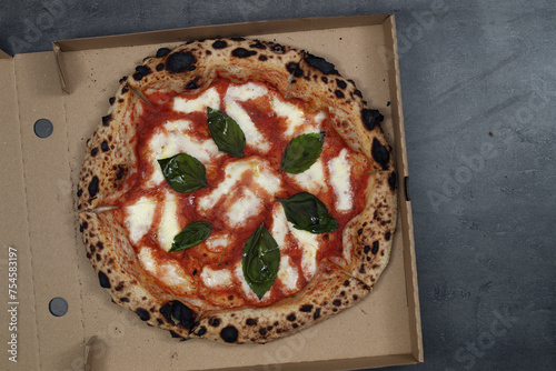 Best owen baked italian pizza margherita. Top view on pizza in delivery paper box.