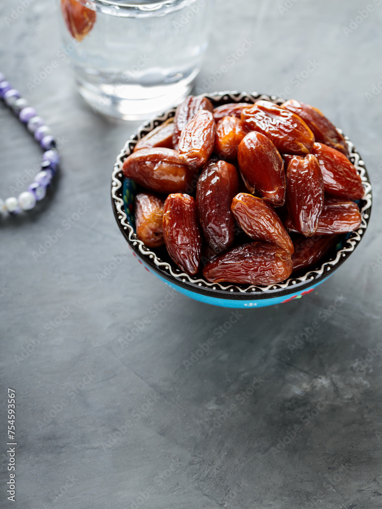 Dried Dates and Water Glass on Gray Concrete, Ramadan Suhoor Concept, Copy Space Dried Dates and Water Glass on Gray Concrete, Ramadan Suhoor Concept, Copy Space