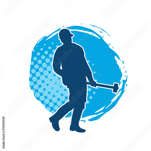 Silhouette of a worker in action pose using his sledge hammer tool.