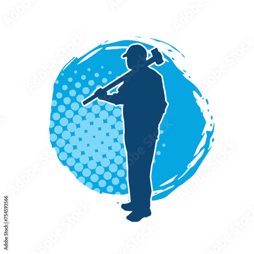 Silhouette of a worker in action pose using his sledge hammer tool.