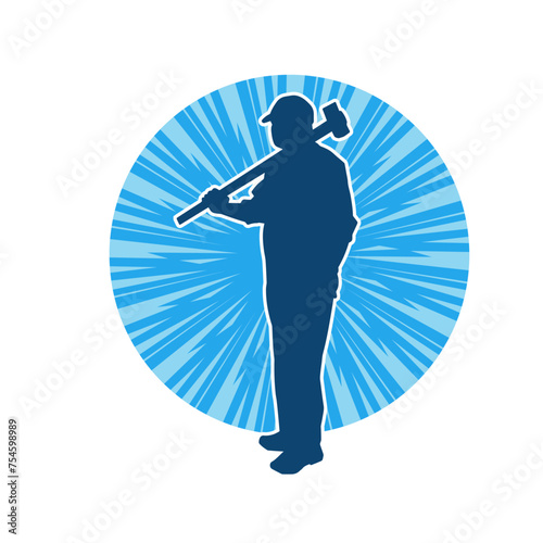 Silhouette of a worker in action pose using his sledge hammer tool.
