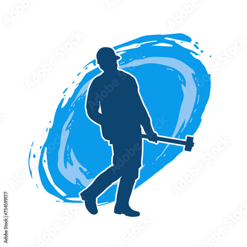 Silhouette of a worker in action pose using his sledge hammer tool.
