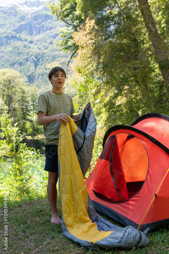 Teenager preparing the tent and sleeping bag for camping in Patagonia.