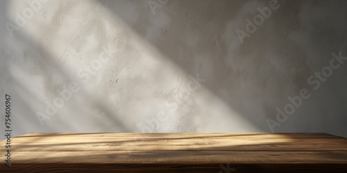 Warm sunlight casts dramatic shadows on a rustic wooden table against a textured stucco wall.