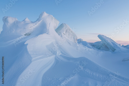 Winter arctic landscape. Cold frosty winter weather. Harsh polar climate. Ice hummocks on the frozen sea in the Arctic. View of snow and ice at sunset. Picturesque nature of the Arctic. Far North. © Andrei Stepanov