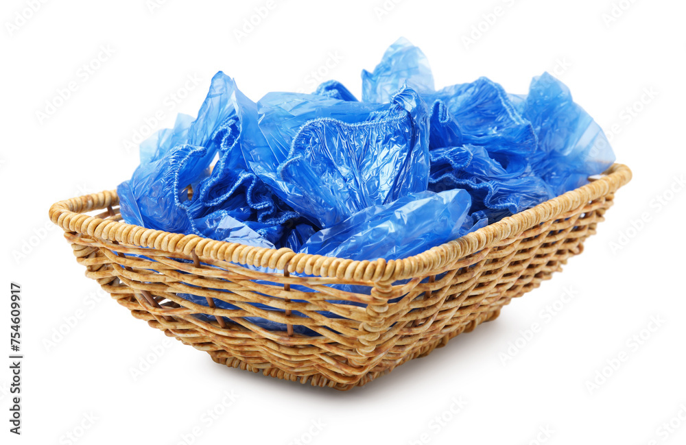 Obraz premium Blue medical shoe covers in wicker basket isolated on white