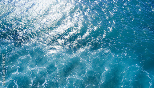 Abstract image from top view of wave on clear blue sea surface glitter in sunlight