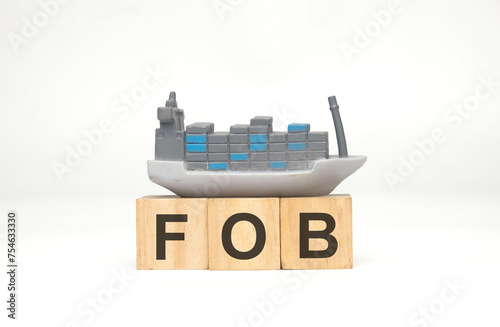 A picture of vessel miniature with wooden block written FOB. Free on board. photo