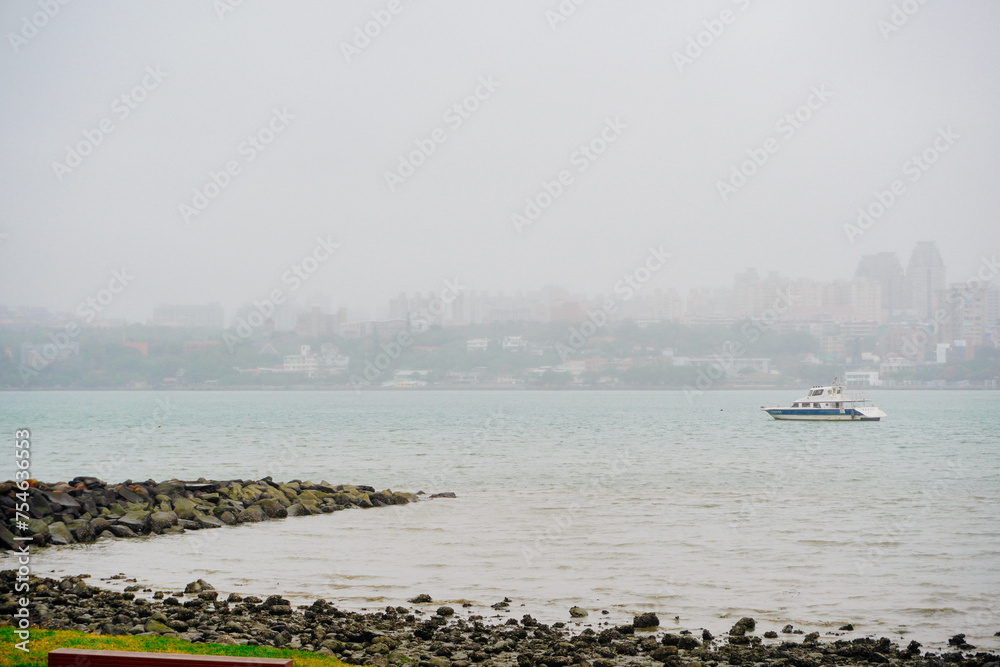 Bali, New Taipei, Taiwan, Republic of China, 01 22 2024: Cruise ferry boat and port on Clean Tamsui river in a raining day in winter Bali, New Taipei, Taiwan, Republic of China, 01 22 2024: Cruise ferry boat and port on Clean Tamsui river in a raining day in winter