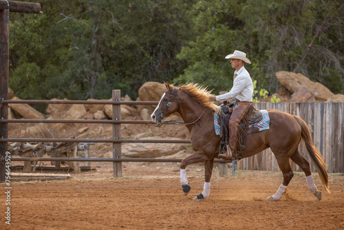 Obraz na plátně Cowboy Trainer riding a sorrel quarter horse