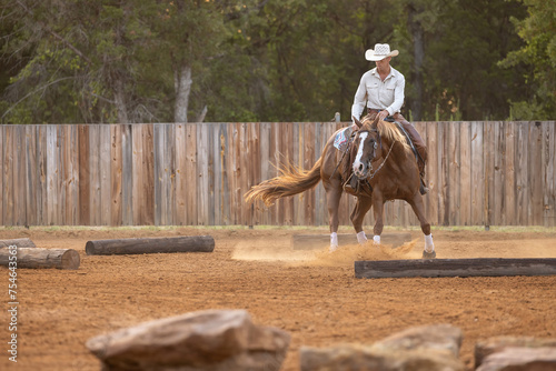 Cowboy Horse Trainer working with horse on spins and obstacles, 