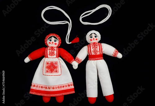 two martenitsa dolls in traditional russian clothing are on a black background photo