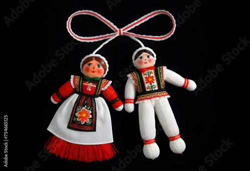 two martenitsa dolls in traditional costumes hanging from a ribbon photo