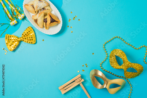Jewish holiday Purim background with carnival mask and hamantaschen cookies. Top view, flat lay  composition