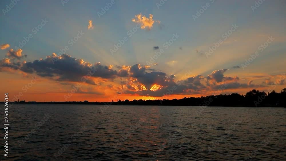 Colorful sunset on the lake Ontario. Spectacular clouds through which the sun's rays shine. Tranquil scene Natural background. Canada Colorful sunset on the lake Ontario. Spectacular clouds through which the sun's rays shine. Tranquil scene Natural background. Canada