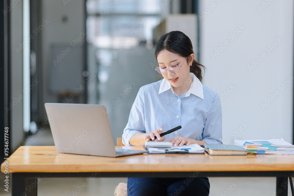 Asian accounting woman working with document paper and laptop computer at table office, Financial and accounting woman concept. Asian accounting woman working with document paper and laptop computer at table office, Financial and accounting woman concept.