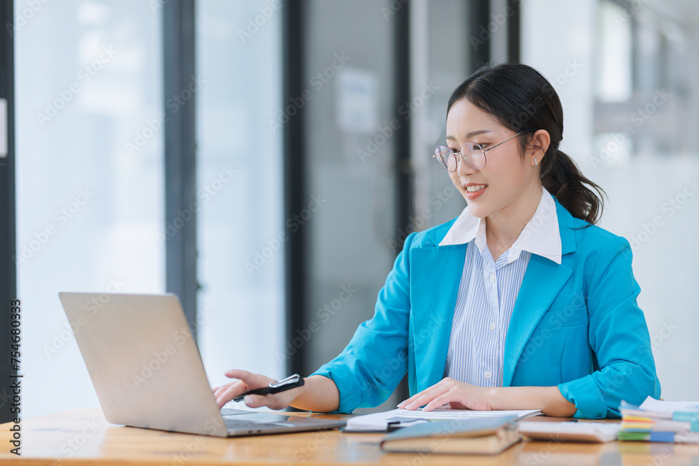 Asian accounting woman working with document paper and laptop computer at table office, Financial and accounting woman concept. 