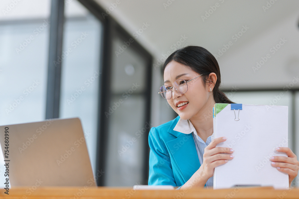 Asian accounting woman working with document paper and laptop computer at table office, Financial and accounting woman concept. Asian accounting woman working with document paper and laptop computer at table office, Financial and accounting woman concept.