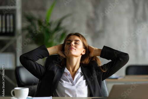 Business woman sitting at office desk, taking break from work and stretching stiff, tense muscles photo